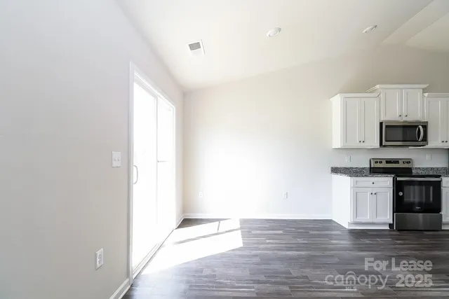 a view of a kitchen with dishwasher and wooden floor
