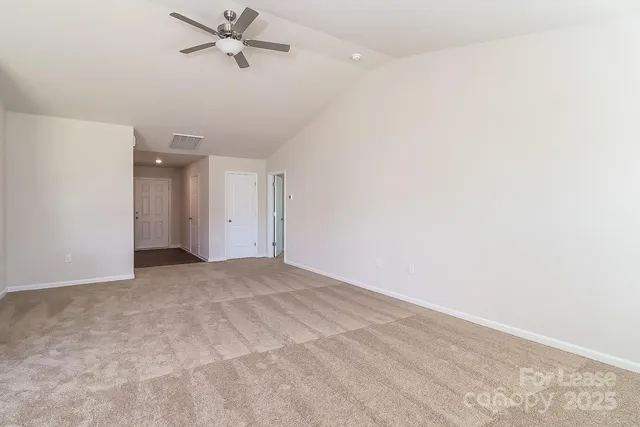 an empty room with a ceiling fan and a window