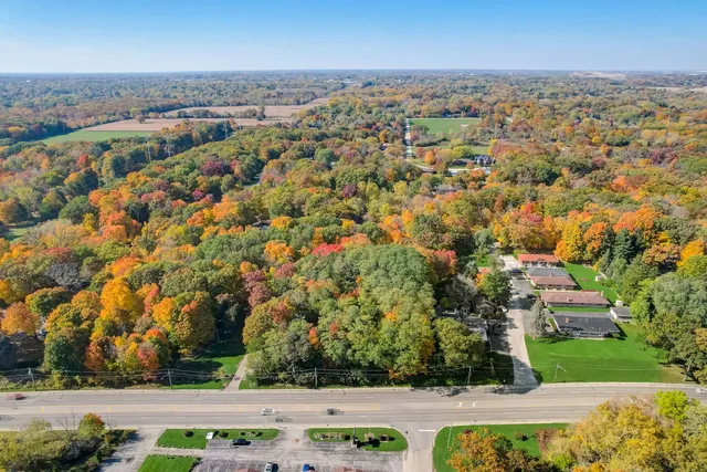 an aerial view of residential house with outdoor space and trees all around