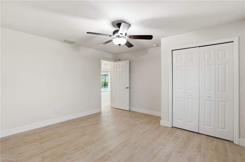 1808 Southwest 30th Street Cape Coral, FL 33914 - Photo 26 of 44 an empty room with wooden floor ceiling fan and windows