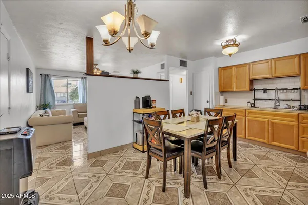 a dining room filled chandelier and kitchen view