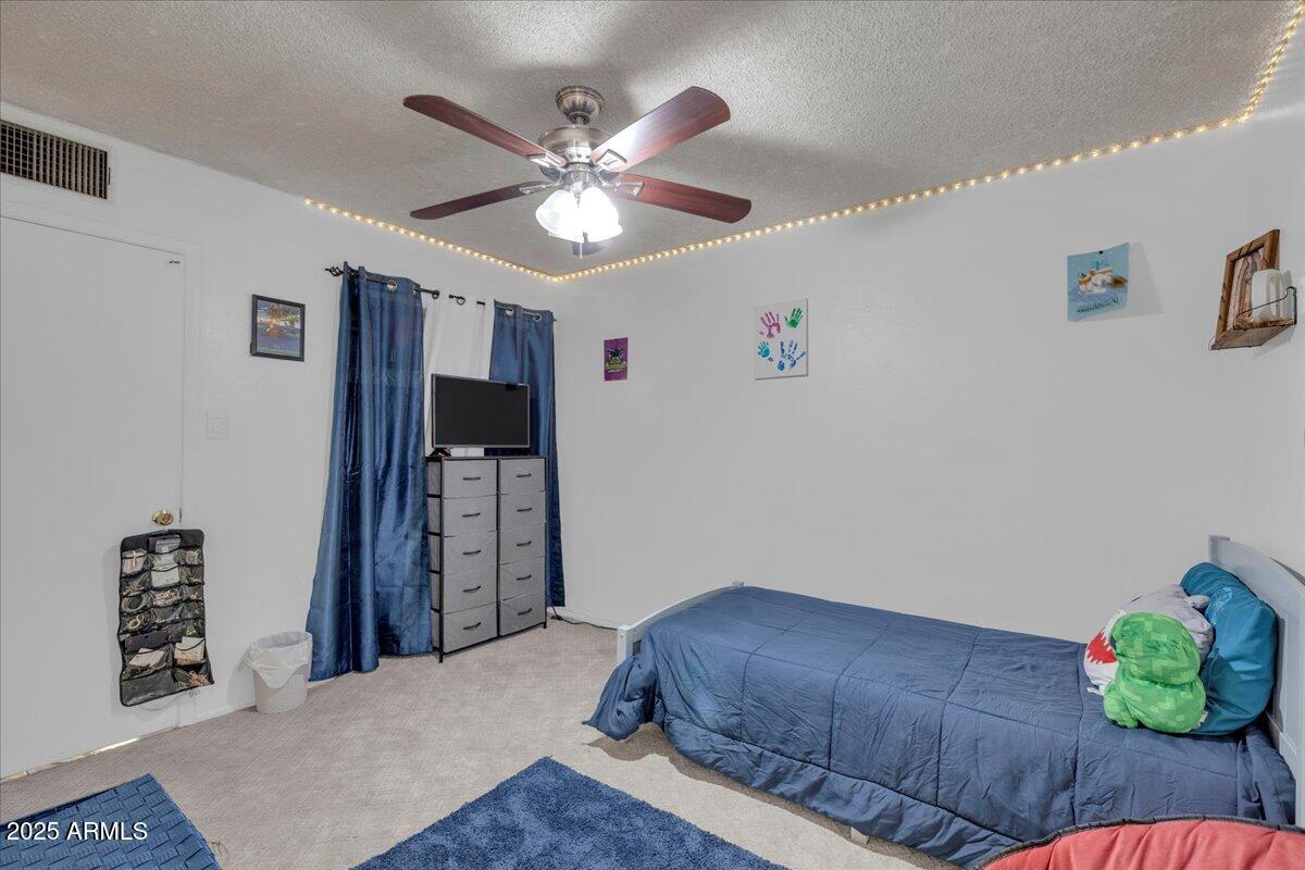 6516 West Cheery Lynn Road Phoenix, AZ 85033 - Photo 12 of 26 a bedroom with a bed and a chandelier