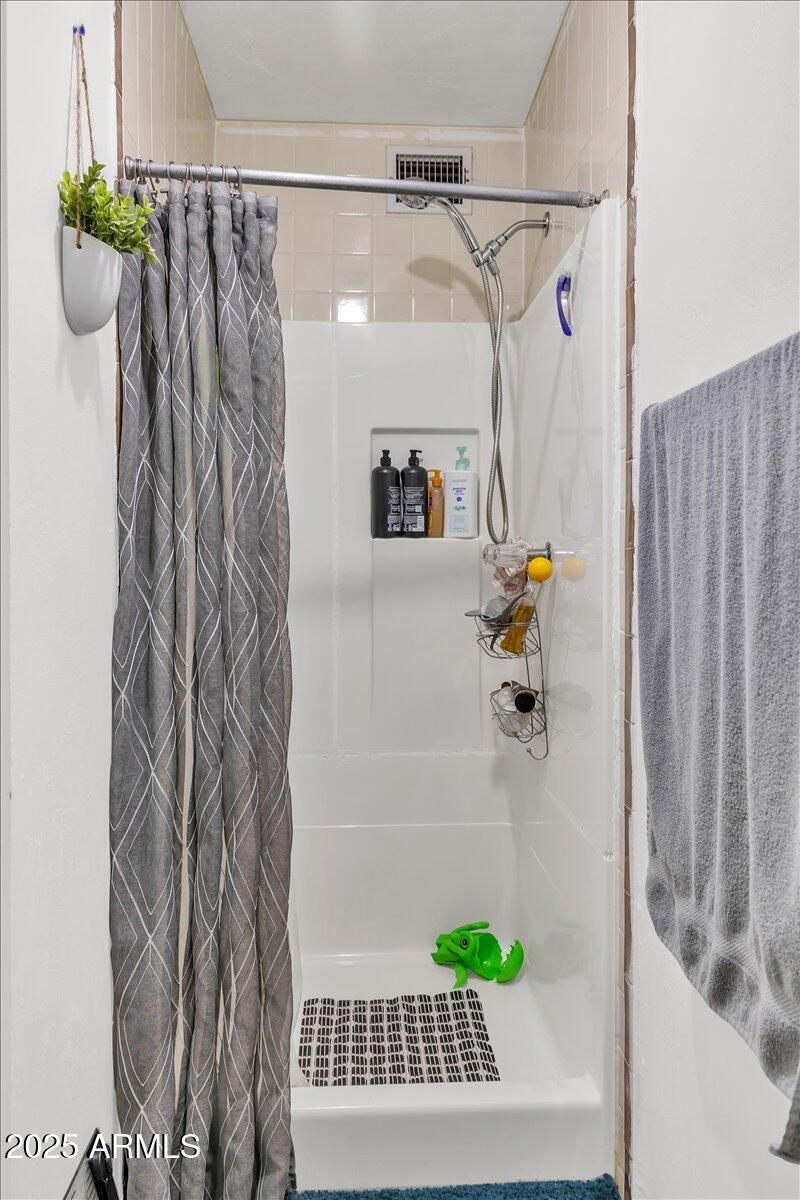 6516 West Cheery Lynn Road Phoenix, AZ 85033 - Photo 20 of 26 a bathroom with a shower curtain and a window