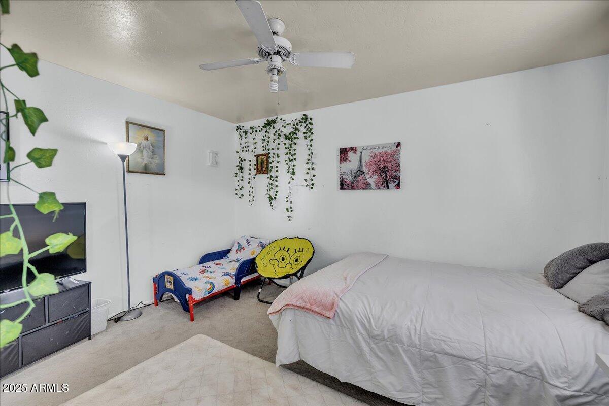 6516 West Cheery Lynn Road Phoenix, AZ 85033 - Photo 23 of 26 a bedroom with a bed and a chandelier