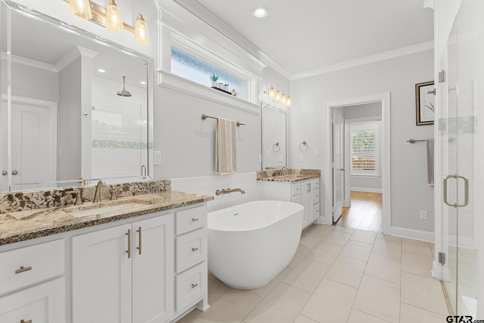 9035 Shallow Cove Tyler, TX 75703 - Photo 13 of 31 a spacious bathroom with a bathtub shower sink double and mirror