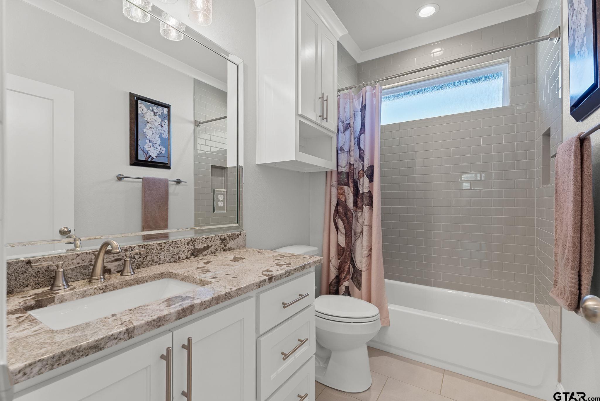 9035 Shallow Cove Tyler, TX 75703 - Photo 17 of 31 a bathroom with a granite countertop sink toilet and shower