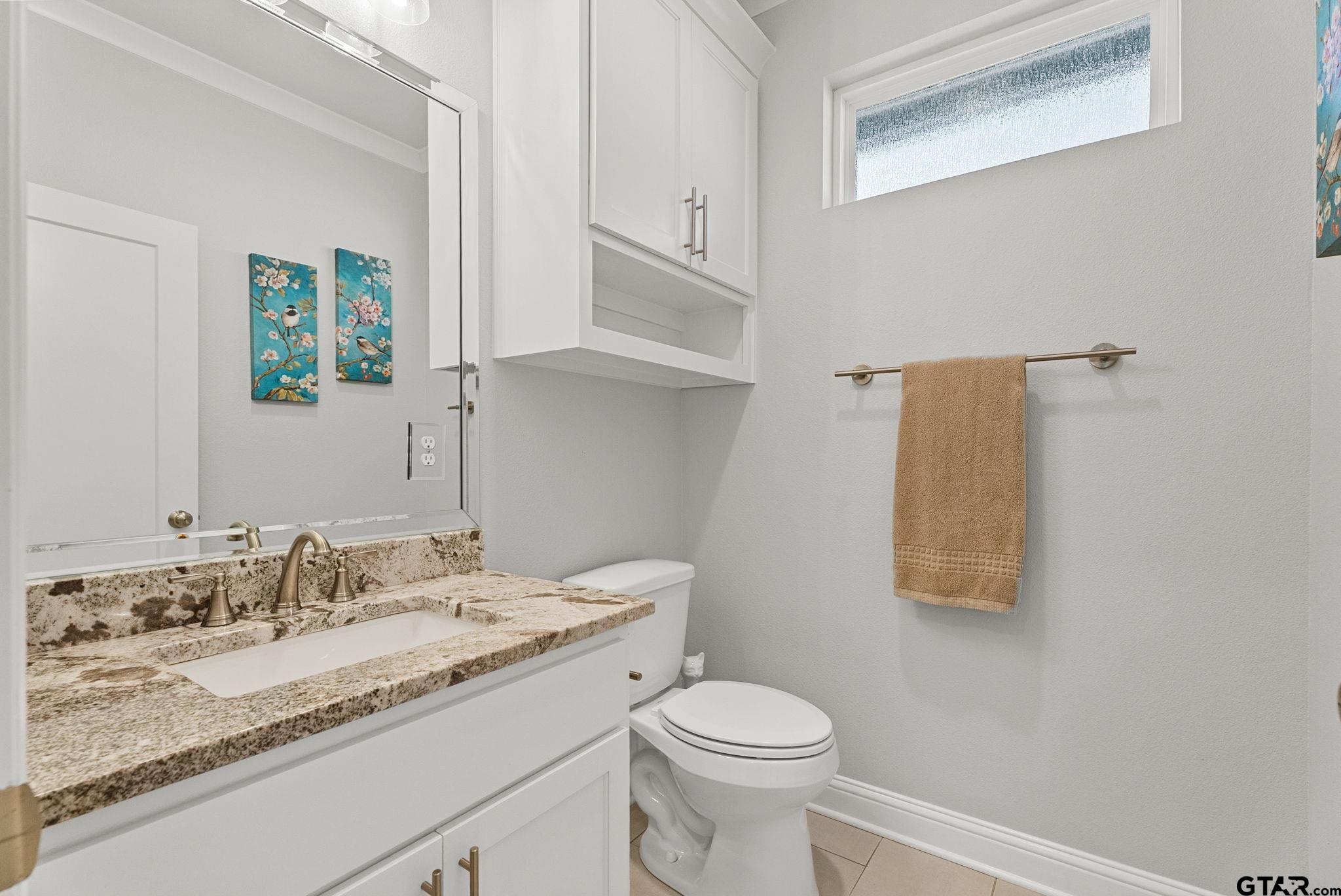 9035 Shallow Cove Tyler, TX 75703 - Photo 22 of 31 a bathroom with a granite countertop sink a toilet and a mirror
