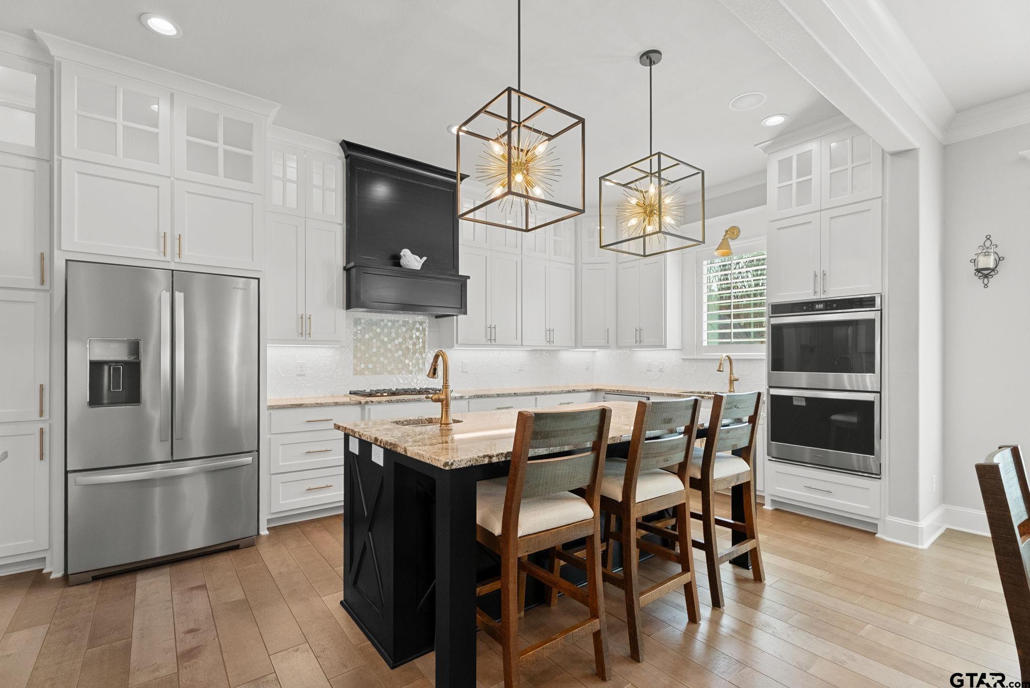 9035 Shallow Cove Tyler, TX 75703 - Photo 8 of 31 a kitchen with stainless steel appliances a dining table chairs refrigerator and microwave