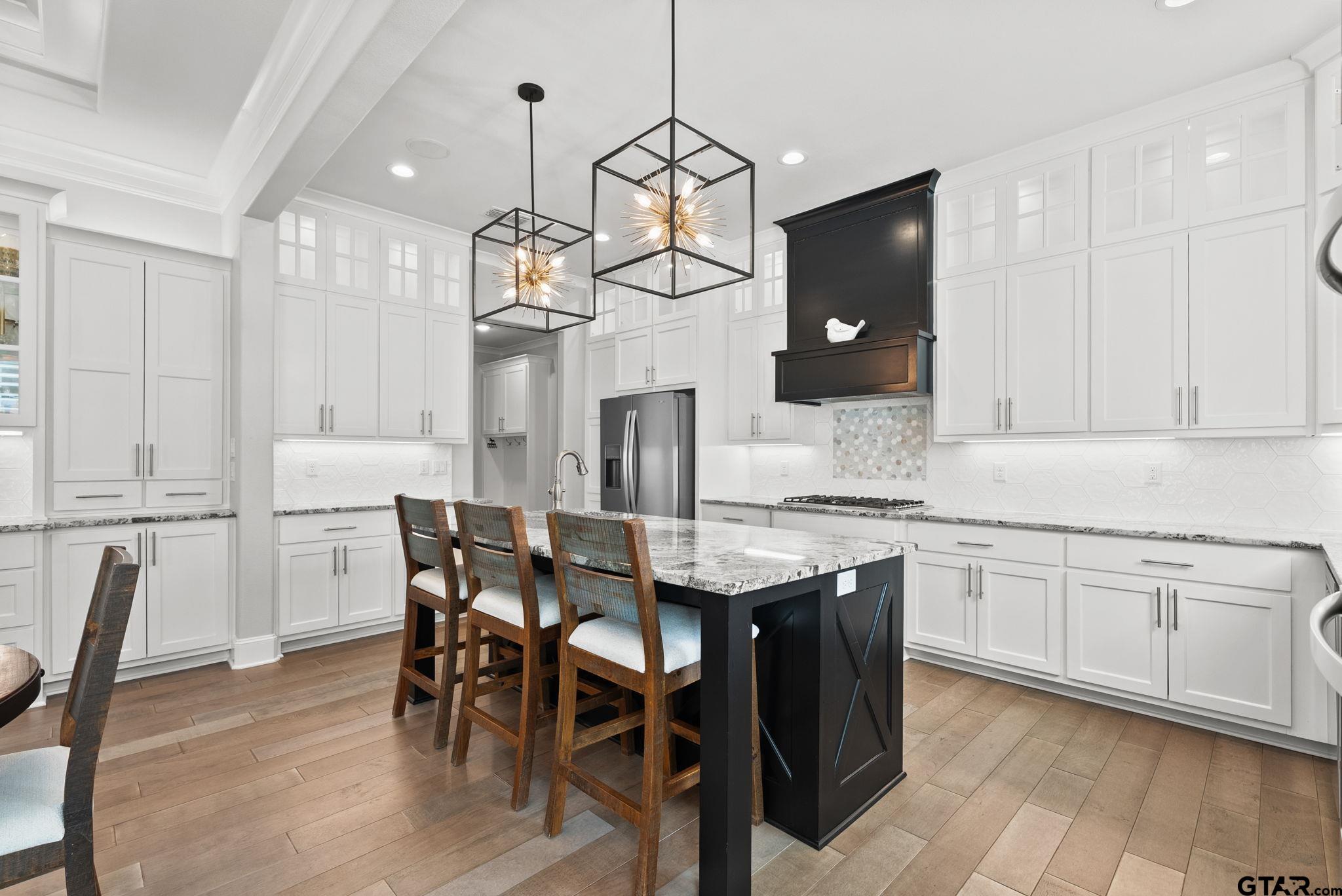 9035 Shallow Cove Tyler, TX 75703 - Photo 9 of 31 a kitchen with stainless steel appliances granite countertop a kitchen island a stove a table and chairs in it