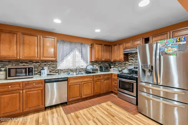 a kitchen with granite countertop stainless steel appliances and wooden cabinets