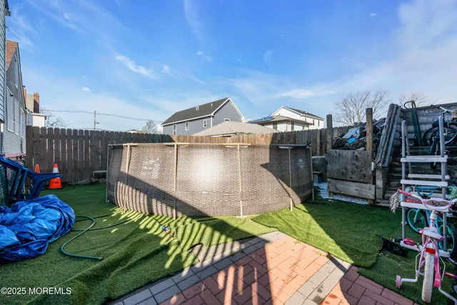 a view of a house with a backyard and a wooden deck