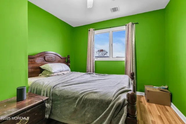 a bedroom with a bed and wooden floor
