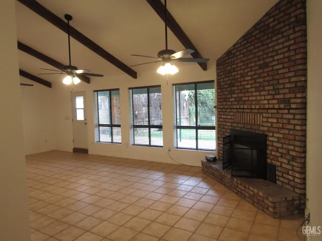 a view of an empty room with a fireplace and a window