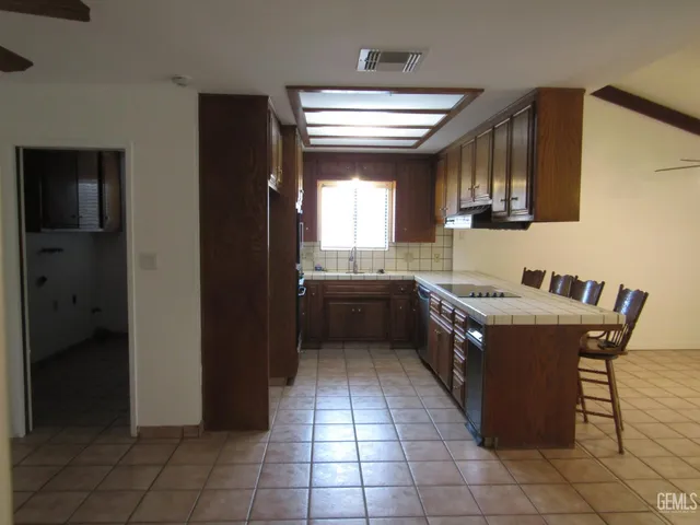 a large kitchen with stainless steel appliances granite countertop a sink and cabinets