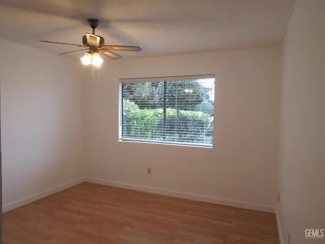 an empty room with a window and a fan