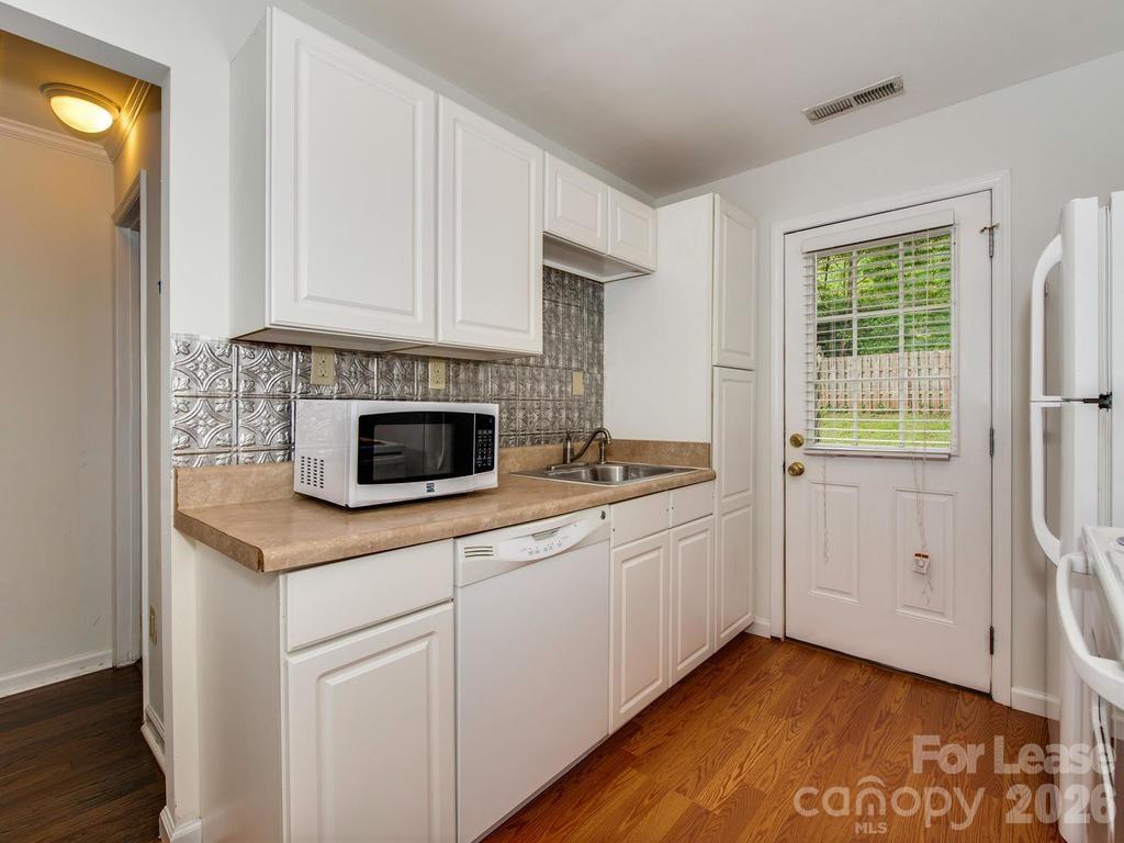 5113 Valley Stream Road Charlotte, NC 28209 - Photo 12 of 17 a kitchen with stainless steel appliances a sink and a fireplace