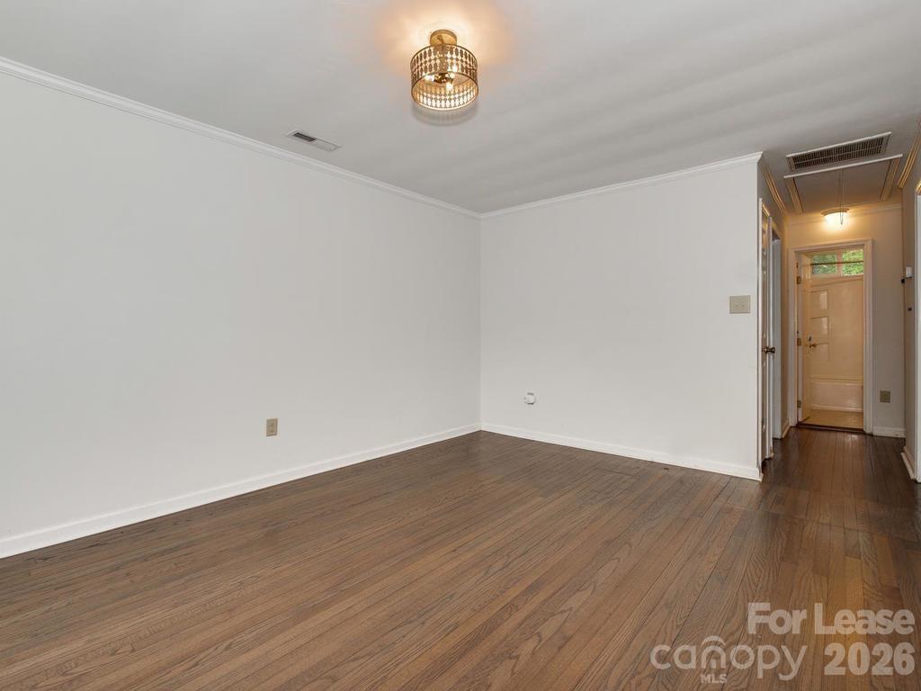 5113 Valley Stream Road Charlotte, NC 28209 - Photo 7 of 17 a view of an empty room with wooden floor and a window