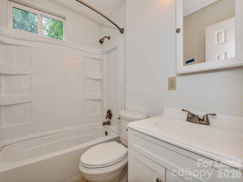 5113 Valley Stream Road Charlotte, NC 28209 - Photo 10 of 17 a bathroom with a sink a toilet and shower