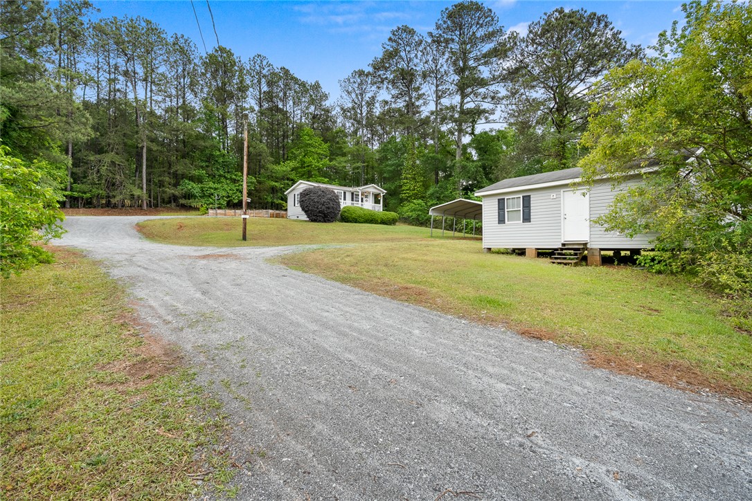 111 State Rd S-4-104 Anderson, SC 29626 - Photo 26 of 42 This charming property features a gravel driveway leading to a secluded home, surrounded by lush trees.