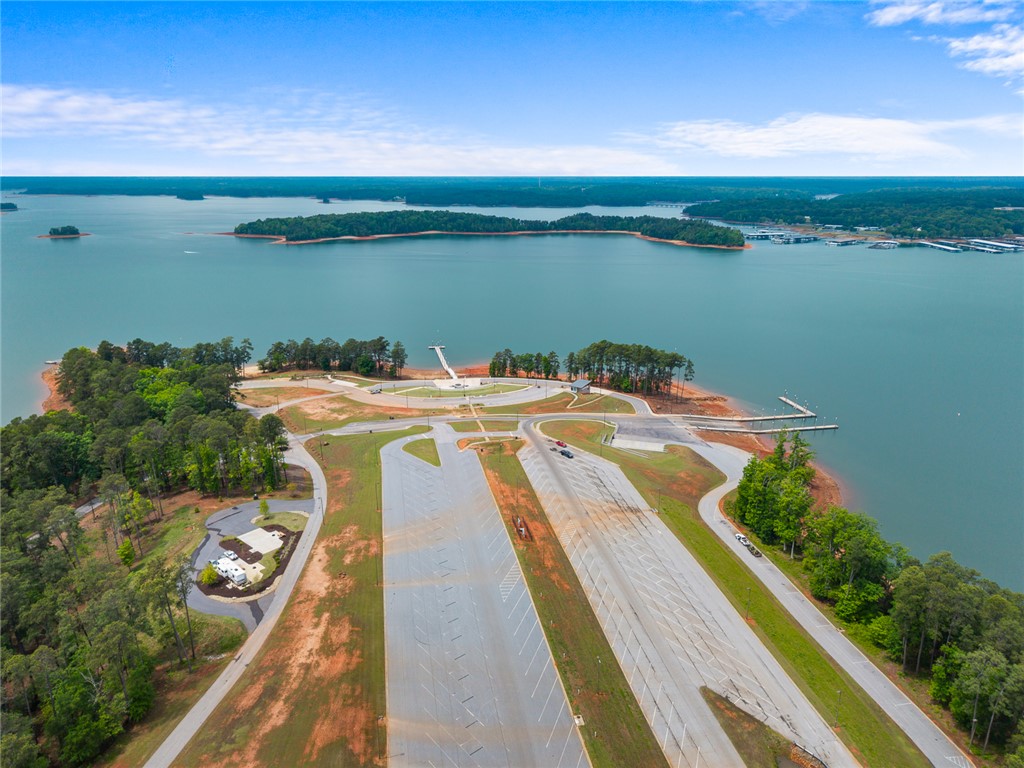 111 State Rd S-4-104 Anderson, SC 29626 - Photo 31 of 42 This aerial view showcases a vibrant lake with boat docks and ample parking, surrounded by lush trees.