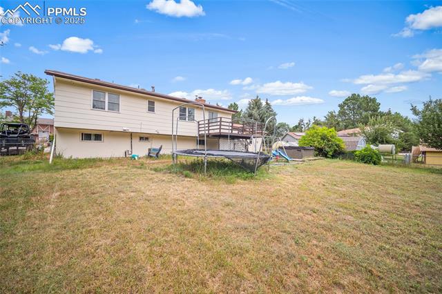 1921 Wooten Road Colorado Springs, CO 80915 - Photo 35 of 49 Rear view of property featuring a trampoline