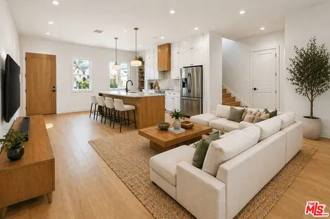 a living room with furniture kitchen and a chandelier