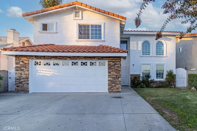 a front view of a house with a garden and garage
