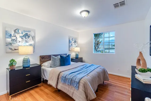 a bedroom with a bed and wooden floor
