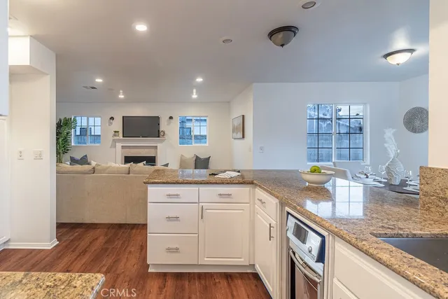 a kitchen with a sink dishwasher a stove a microwave oven with wooden floor and cabinets