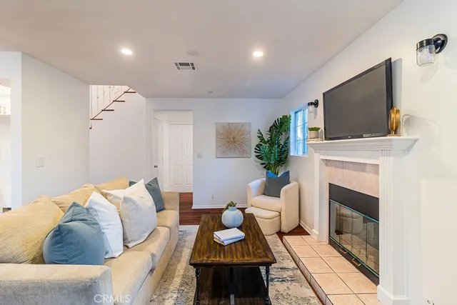 a living room with furniture a fireplace and a flat screen tv