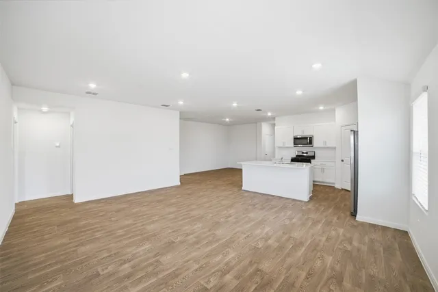 a big yard with large trees and wooden fence