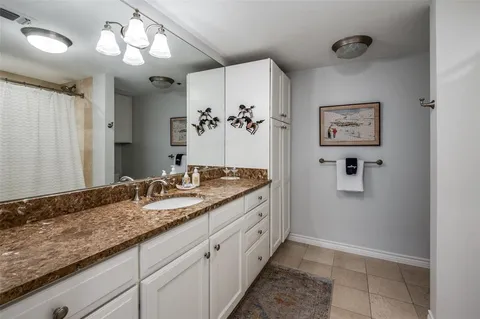 a bathroom with a granite countertop sink a mirror and a vanity