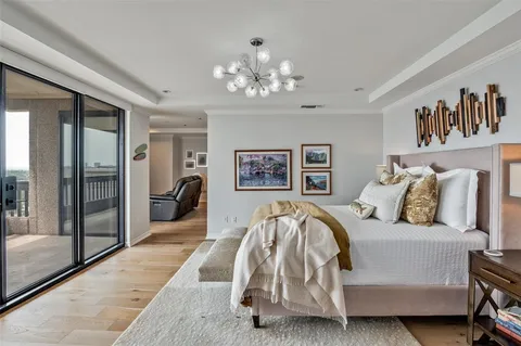 a spacious bedroom with a bed and a chandelier