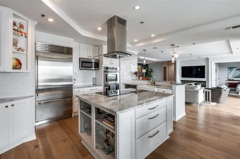 a kitchen with stainless steel appliances kitchen island granite countertop a stove refrigerator and a microwave