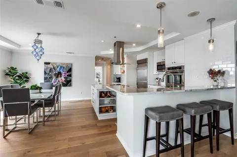 a living room with furniture kitchen view and a wooden floor