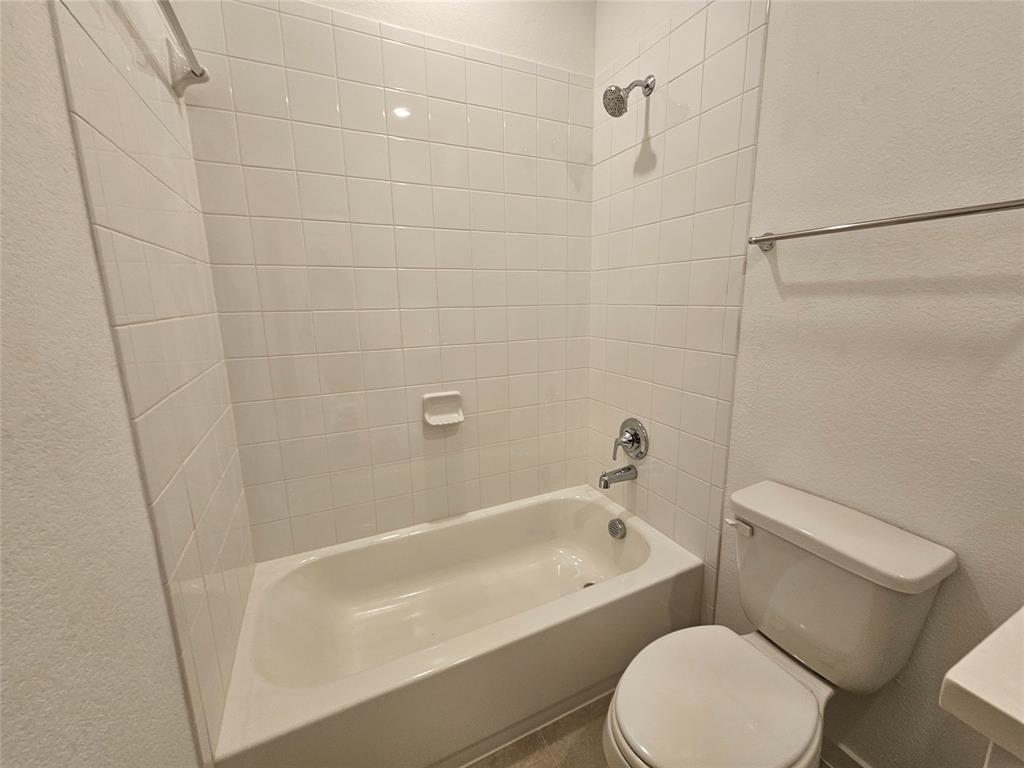 3915 Chesapeake Lane Crandall, TX 75114 - Photo 16 of 32 a white toilet and tub sitting next to a bathroom sink