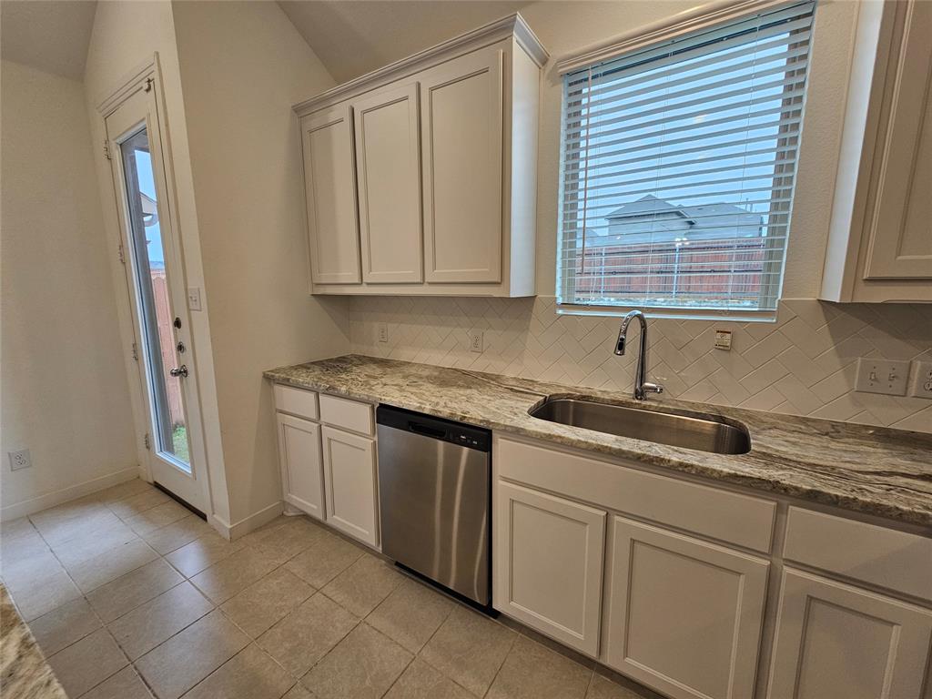 3915 Chesapeake Lane Crandall, TX 75114 - Photo 4 of 32 a kitchen with granite countertop a sink and a white cabinets