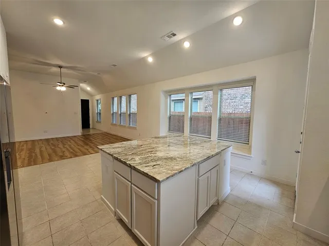 a large white kitchen with a refrigerator a stove a sink and a cabinets
