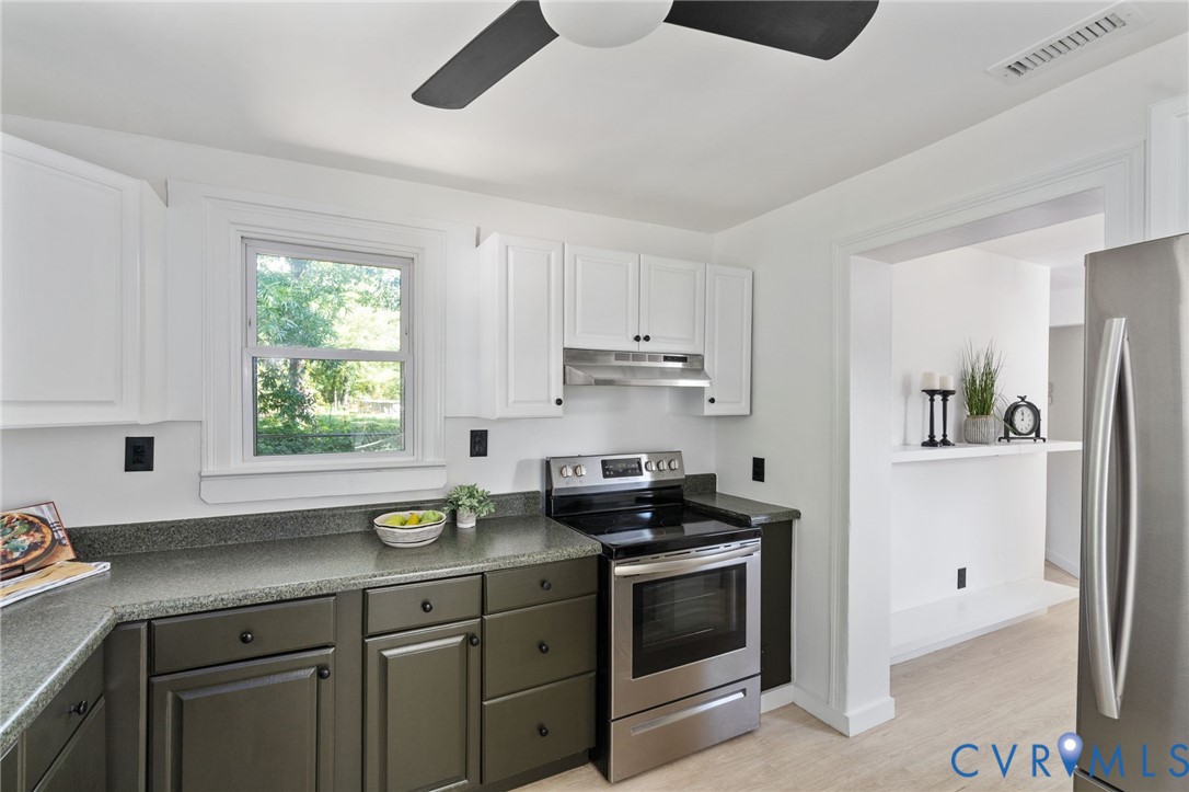 200 Brooks Road Richmond, VA 23223 - Photo 23 of 58 a kitchen with stainless steel appliances granite countertop white cabinets a sink a stove a refrigerator and island with wooden floor