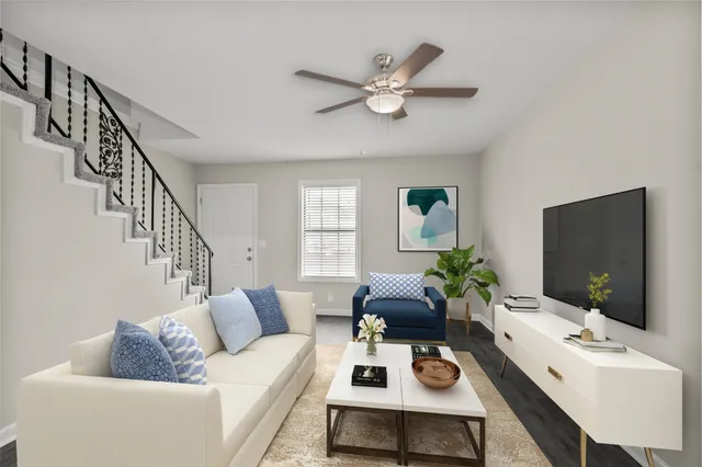 a living room with furniture a flat screen tv and a window