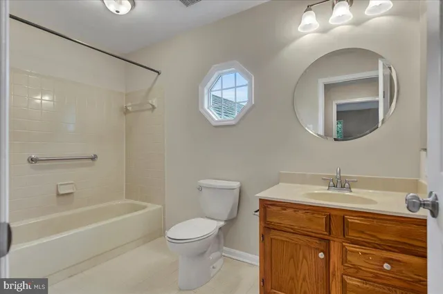 a bathroom with a toilet a sink a mirror and bathtub