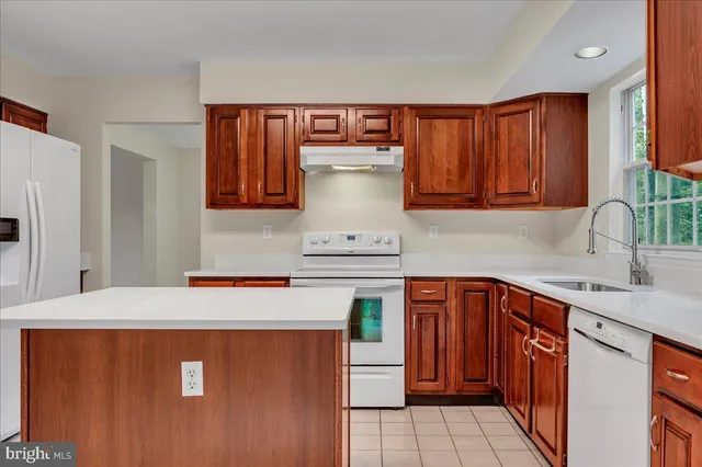 a kitchen with stainless steel appliances granite countertop wooden cabinets a sink and a stove