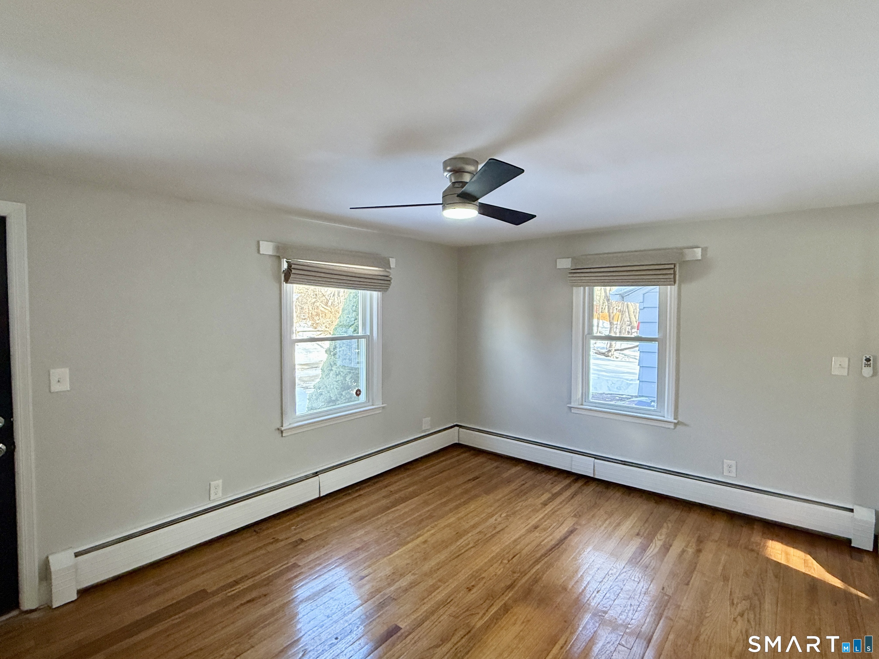 148 Lois Street Torrington, CT 06790 - Photo 8 of 17 an empty room with wooden floor and windows