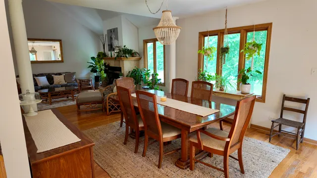 a dining room with furniture a chandelier and wooden floor