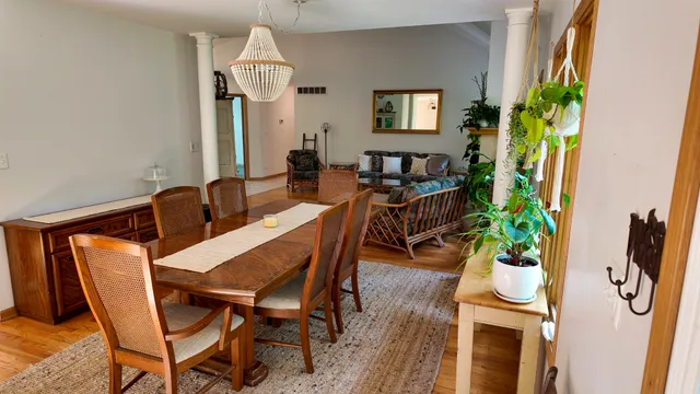 a dining room with furniture a chandelier and wooden floor