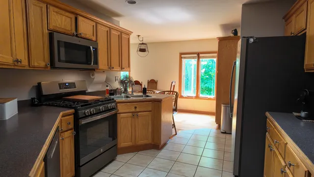 a kitchen with stainless steel appliances granite countertop a stove a refrigerator and a microwave