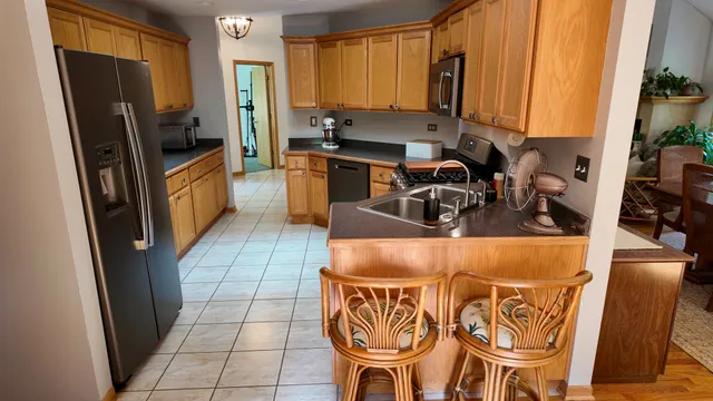 a kitchen with stainless steel appliances a sink a counter top space cabinets and a window