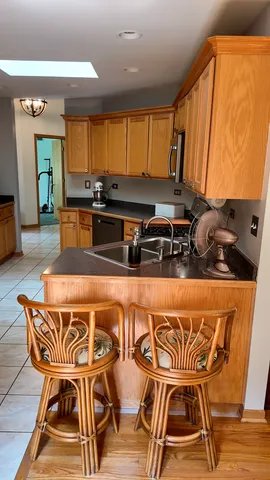 a blue kitchen with stainless steel appliances granite countertop a stove a sink and a microwave