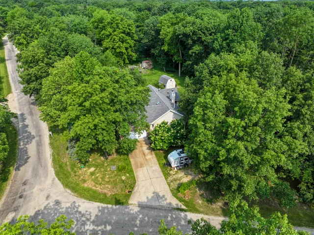 an aerial view of a house with large trees