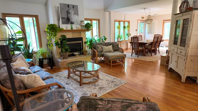 a living room with fireplace furniture and a large window